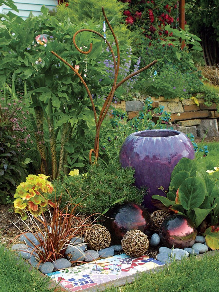 Carefully placed grapevine spheres and glass gazing balls mimic the rounded form of the pottery, while a warm-toned hook sedge repeats the color and form of a rusted-steel sculpture.