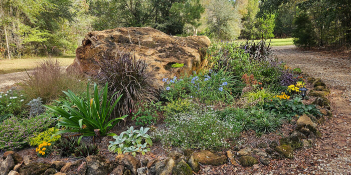 round garden bed with large boulder in the center