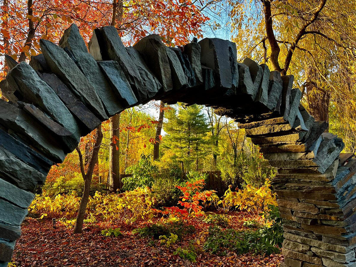 close up of moon gate with fall foliage behind