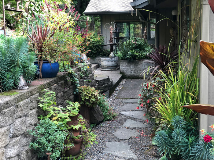 stepping stone path leading to patio with container plantings all around